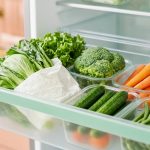 Cara menyimpan sayur agar awet: laci kulkas berisi sayur daun berbungkus tisu, brokoli, wortel, timun, dan buncis dalam wadah kaca