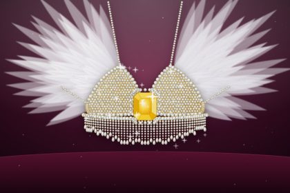 Ilustrasi Fantasy Bra Kylie Jenner bertabur berlian dengan batu kuning di tengah dan sayap bulu putih di atas latar beludru